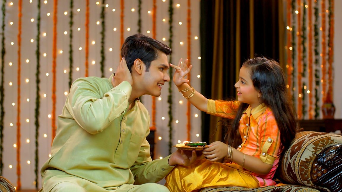 Young siblings celebrating Raksha Bandhan or Bhai Dooj festival together - Happy family , Indian Model